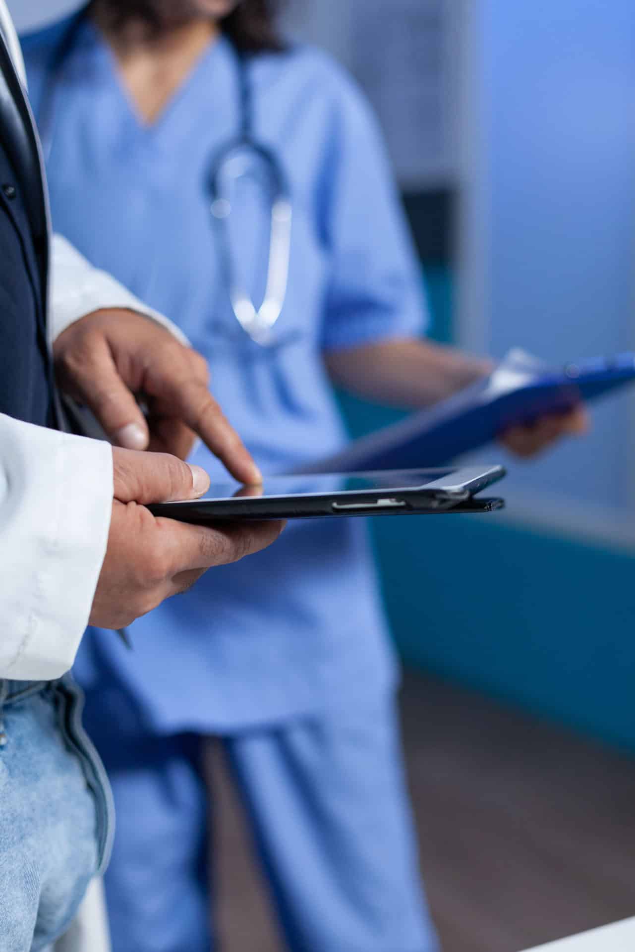 close-up-medic-pointing-tablet-screen-medical-practice-working-late-doctor-using-modern-device-with-touch-screen-talking-assistant-about-healthcare-system-overtime
